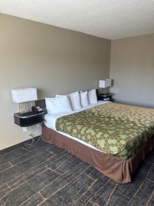 a bed in a hotel room with two lamps and a bed sidx sidx sidx sidx at Rodeway Inn in Webster