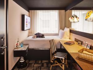 a hotel room with a bed and a desk at Mama Shelter London - Shoreditch in London