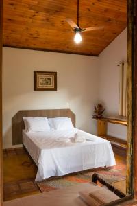 - une chambre avec un lit et un plafond en bois dans l'établissement Pousada Casa da Moeda, à Brumadinho