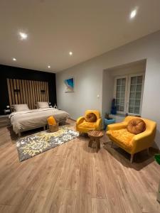 ein Schlafzimmer mit einem Bett und zwei Sofas und einem Bett und einem Bett in der Unterkunft Chambre privée avec salle de bain in Domagné