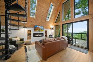 Una sala de estar con un sofá y una chimenea. en Alpine A-Frame at Calm Ridge Treehouses, en Boone