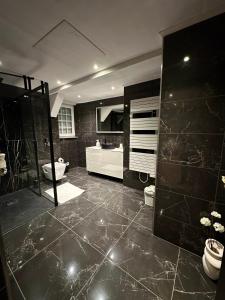 ein großes Bad mit einer Dusche und einem Waschbecken in der Unterkunft Chambre privée avec salle de bain in Domagné