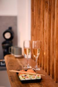 a table with two glasses of wine and a plate of sushi at Suite - Le Lotus de Conflans in Conflans-Sainte-Honorine +12 photos