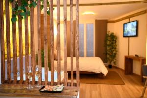 a hotel room with a bed and a table with wine glasses at Suite - Le Lotus de Conflans in Conflans-Sainte-Honorine