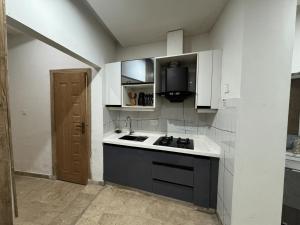 a kitchen with a sink and a stove in it at Studio Apartment in Dargai