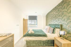 Un dormitorio con una cama con un edredón verde. en Seaside Apartments Ramsgate, en Ramsgate