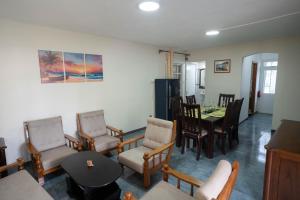 a living room with chairs and a table and a dining room at Seaview Apartment by Beach in Flic-en-Flac +4 photos