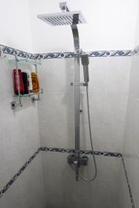 a shower with a shower head in a bathroom at Seaview Apartment by Beach in Flic-en-Flac