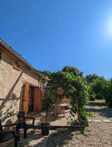 un patio di una casa con tavolo e albero di La Sacristie a Graulhet