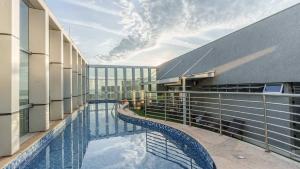 a balcony with a swimming pool on a building at Fusion Hplus Express + in Brasília