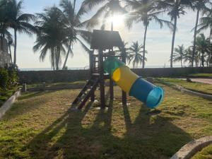 a slide in a park with palm trees at Apartamento con vista al mar in Tucacas