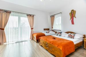 Un dormitorio con dos camas y una gran ventana. en Willa Pod Wierchem, en Bukowina Tatrzańska