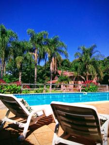 two lawn chairs sitting next to a swimming pool at Cavalheiro de Monte Cristo in Ivoti