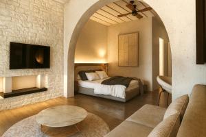 a bedroom with a bed and a living room at Tholaria Boutique Hotel in Astypalaia Town