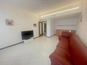 a living room with a couch and a flat screen tv at Casa Caterina in Alassio