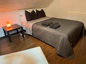a bedroom with a bed with two pillows and a table at Gemütliche Wohnung, Heimkino, Couch & Küche in Siegen