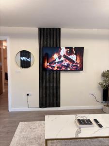 a living room with a tv on a wall at Lux Stays - 2BR Leeds City Centre Apartment - Ground Floor with Free Parking in Leeds