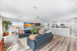 a living room with two couches and a kitchen at HeatedPool HotTub 3min2Beach GameRm PetFriendly in Saint Augustine