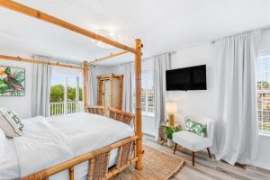 a bedroom with a wooden canopy bed and a tv at HeatedPool HotTub 3min2Beach GameRm PetFriendly in Saint Augustine +59 photos