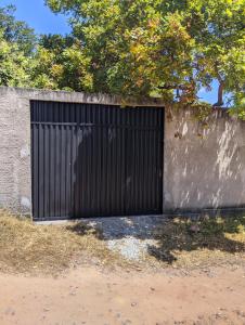 une porte de garage noire sur un mur en béton dans l'établissement Casa Linda Barrerinhas - Ma, à Barreirinhas