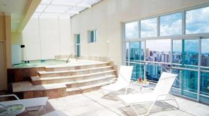 a bathroom with a jacuzzi tub and white chairs at HOTEL PERDIZES - FLAT Executivo - 1402 in Sao Paulo
