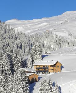 a ski lodge in the snow on a mountain at Flora Alpinea in Damuls