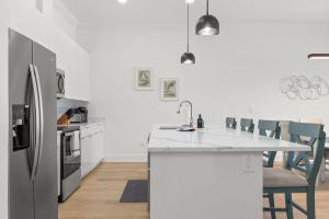 a kitchen with a refrigerator and a table with chairs at NEW Casa Cielo - Gorgeous Newly Built Tampa Home in Tampa +20 photos