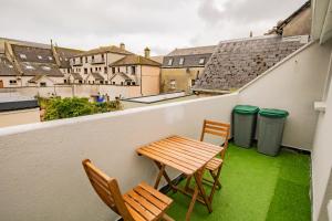 a balcony with a table and two chairs and two trash cans at Location! Location! City Centre Townhouse Sleeps 6 in Galway