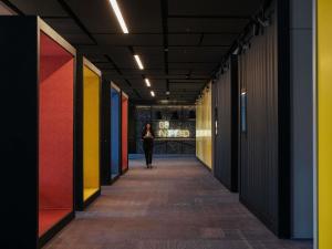 a woman walking down a hallway with colorful walls at Novotel Bishkek City Center in Bishkek