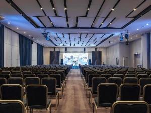 an empty hall with chairs and a projection screen at Novotel Bishkek City Center in Bishkek