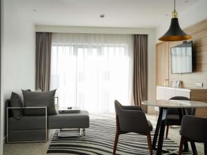 a living room with a couch and a table at Novotel Bishkek City Center in Bishkek +145 photos