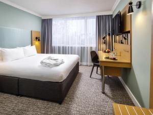 a hotel room with a bed and a desk at The Harlow Hotel By AccorHotels in Harlow +78 photos