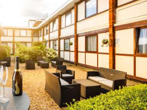 a patio with chairs and a bottle of wine at The Harlow Hotel By AccorHotels in Harlow