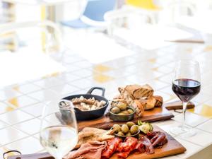 a table with a plate of food and a glass of wine at ibis Styles East Perth in Perth