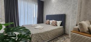 a bedroom with a bed with two towels on it at Zara premium apartment 66 in Stantsiya Kyzyl-Tukumachi