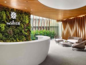 a lobby with chairs and a green wall at The Silveri Hotel Hong Kong - MGallery Collection in Hong Kong