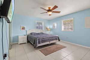 a bedroom with a bed and a ceiling fan at Ocean Song House in Fort Pierce
