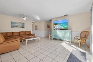 a living room with a couch and a flat screen tv at Ocean Song House in Fort Pierce