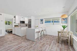 a kitchen with white cabinets and a table and chairs at Little Palm Cottage in Vero Beach