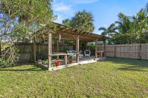 a wooden gazebo in a yard with a fence at Ocean Song House in Fort Pierce