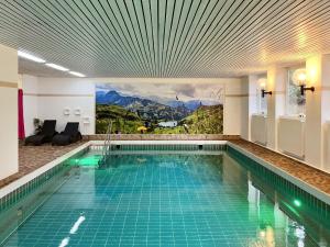 a pool in a hotel with a painting on the wall at Waldgeflüster, Montana Haus in Oberstdorf