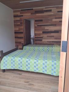 a bedroom with a bed with a wooden wall at Piezas estilo departamento en casa Pucón in Pucón