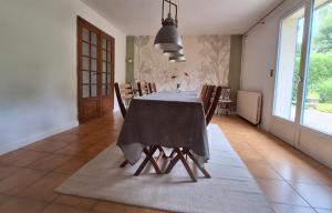 una sala da pranzo con tavolo e sedie di Maison Équilibre a Royère-de-Vassivière