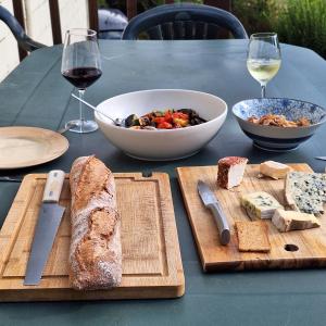 un tavolo con pane e una ciotola di cibo e vino di Maison Équilibre a Royère-de-Vassivière
