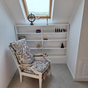una sedia seduta in una stanza con finestra di Maison Équilibre a Royère-de-Vassivière