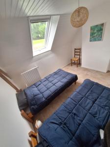 una camera da letto con due letti e una finestra di Maison Équilibre a Royère-de-Vassivière