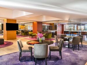 バンガロールにあるGrand Mercure Bengaluru at Gopalan Mall - An Accor Brandのホテルのロビー(テーブル、椅子、テレビ付)