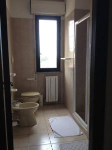 a bathroom with a toilet sink and a window at Villa Dei Romanzi in Tortoreto Lido