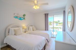 two beds in a room with a view of the ocean at Siesta Key Exclusive Beachside Compound 3 Units in Point O'Rocks +56 photos