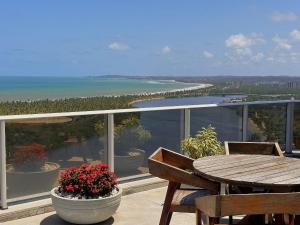 a balcony with a table and chairs and the ocean at Boho Luxo Sunset | Hidro, Alexa Top de linha & + in Recife